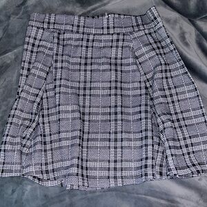 Black/white pleated skirt with elastic waist and zipper.Size L.No stains/tears.